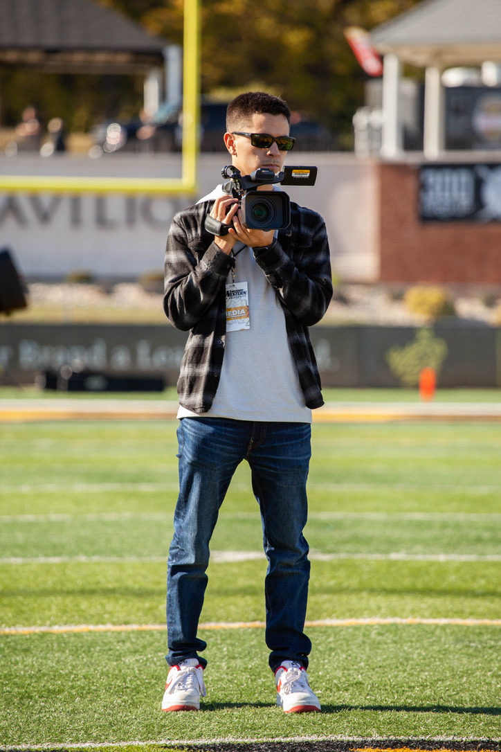 Harry Loomis on the football field holding a camera